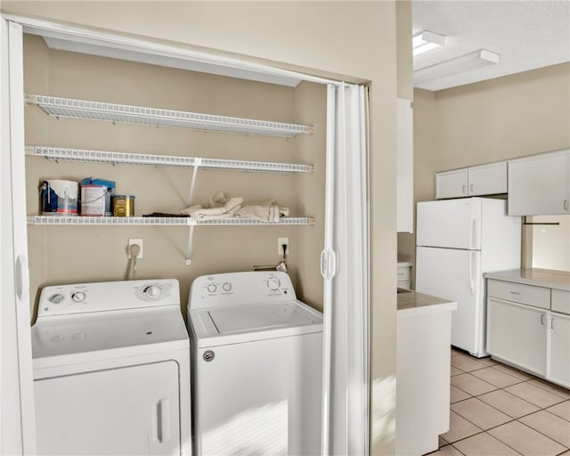 washroom with washer and clothes dryer and light tile patterned floors