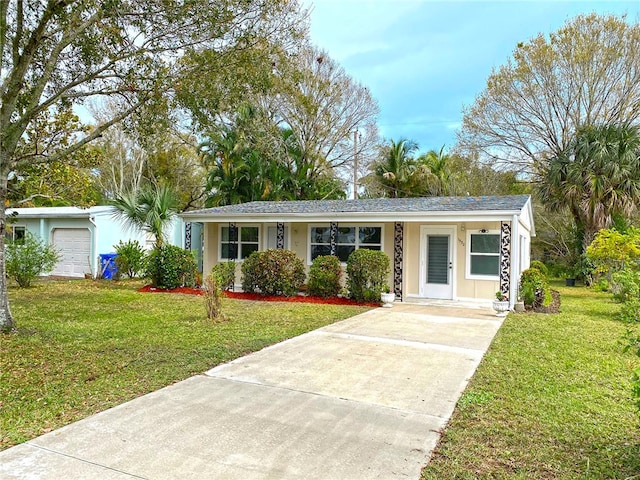 single story home with covered porch, a garage, and a front yard