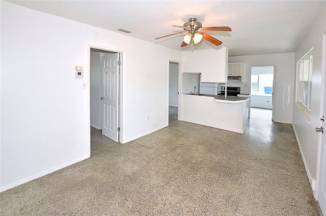 kitchen with white cabinets, ceiling fan, white refrigerator, and kitchen peninsula