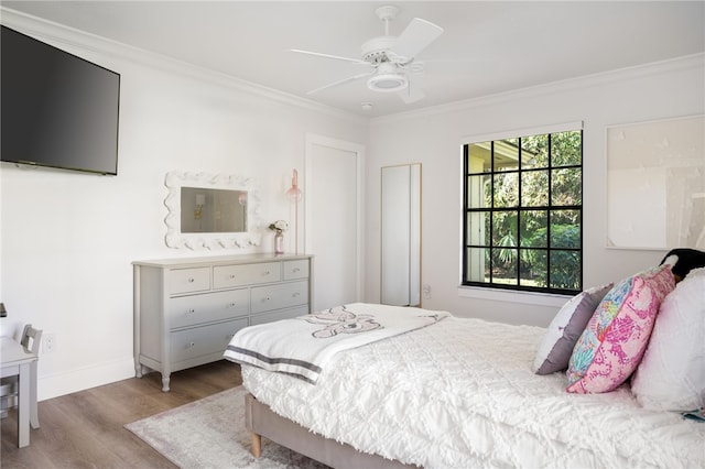 bedroom with ornamental molding, ceiling fan, and light hardwood / wood-style flooring