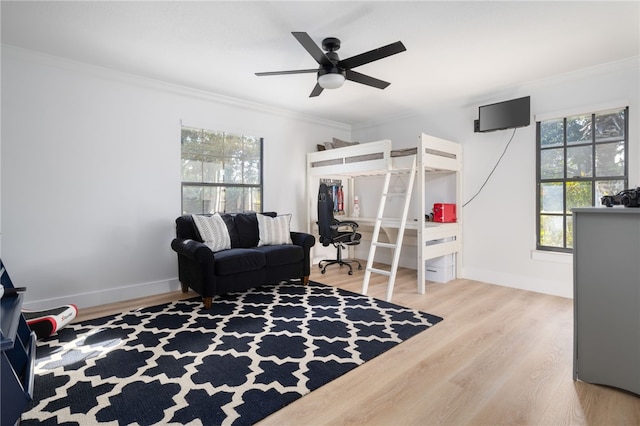 bedroom featuring crown molding, ceiling fan, and light wood-type flooring