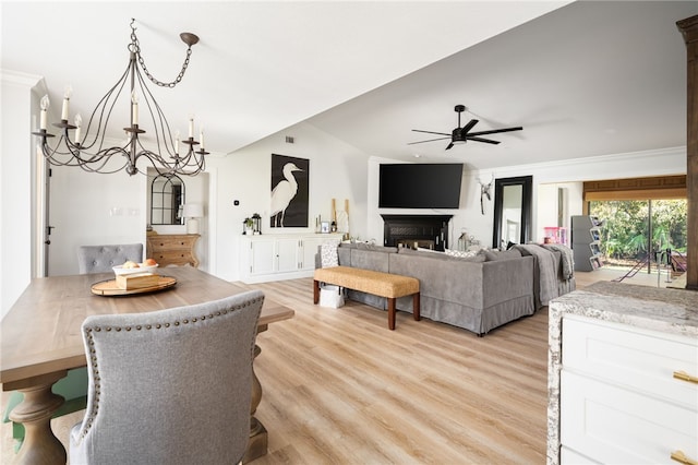 living room featuring ceiling fan with notable chandelier and light hardwood / wood-style flooring