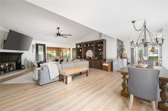 living room with crown molding, lofted ceiling, ceiling fan with notable chandelier, and light wood-type flooring