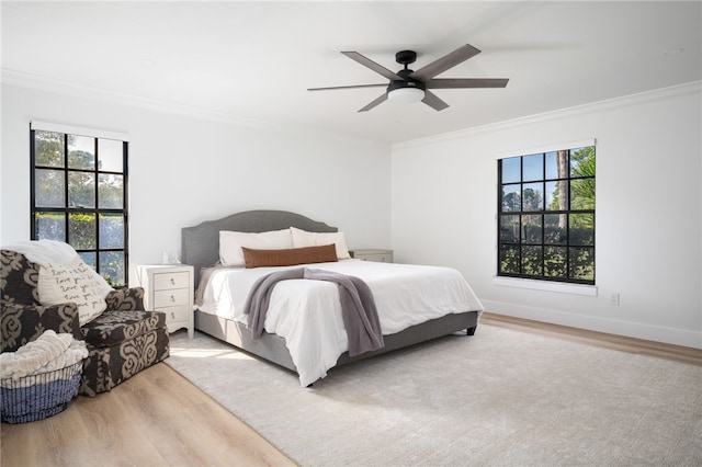 bedroom featuring ornamental molding, ceiling fan, and light wood-type flooring