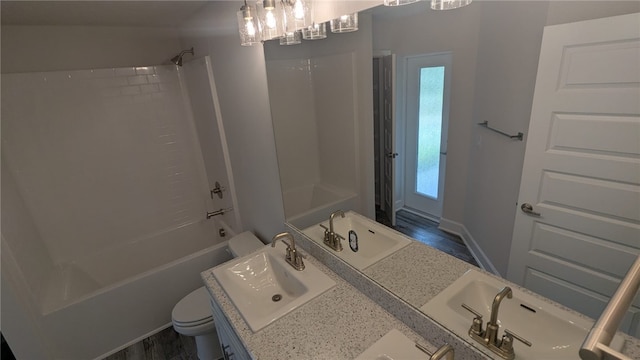 532 S Easy St, Sebastian, FL 32958 - full bathroom featuring toilet, bathing tub / shower combination, double vanity, a chandelier, and wood finished floors