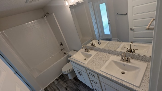 532 S Easy St, Sebastian, FL 32958 - bathroom with double vanity, toilet, wood finished floors, and washtub / shower combination