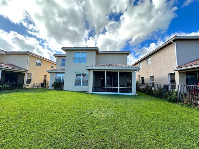 back of house with a lawn, a sunroom, central AC, fence, and a tiled roof