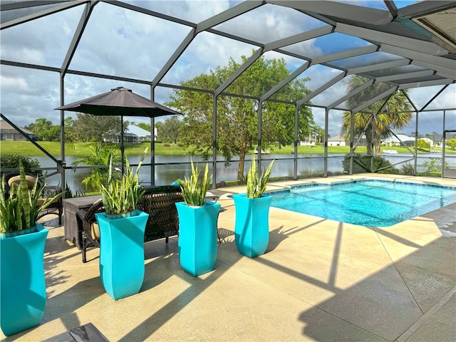 view of swimming pool with glass enclosure, a water view, and a patio area