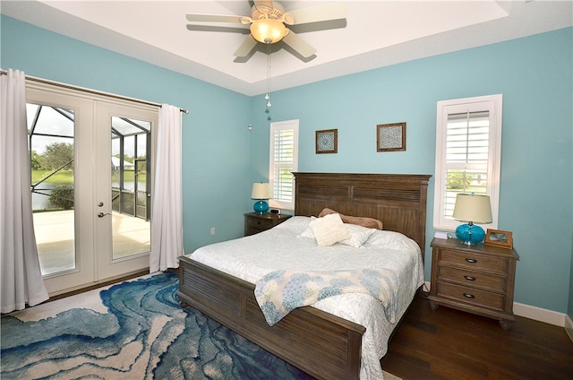 bedroom featuring access to outside, multiple windows, ceiling fan, and dark hardwood / wood-style floors