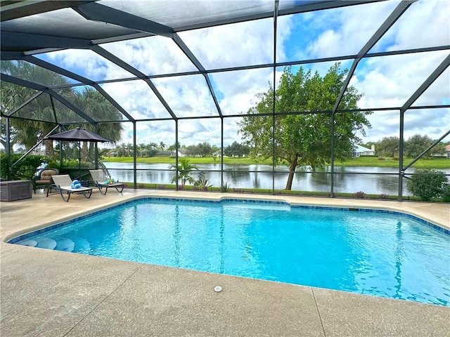 view of pool with a water view, glass enclosure, and a patio area