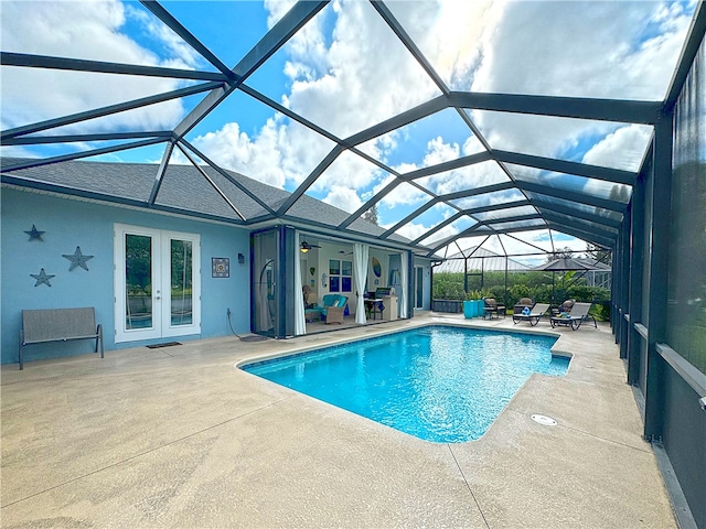 view of swimming pool with a patio, glass enclosure, and french doors