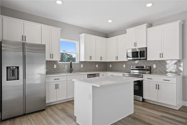 kitchen featuring sink, stainless steel appliances, white cabinets, and a kitchen island