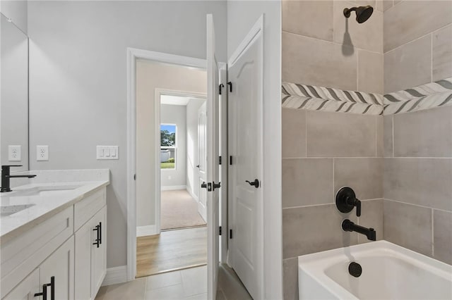 bathroom with tile patterned flooring, tiled shower / bath, and vanity