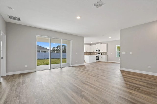 unfurnished living room featuring a healthy amount of sunlight and light wood-type flooring