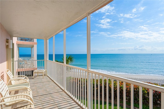 balcony with a water view and a beach view