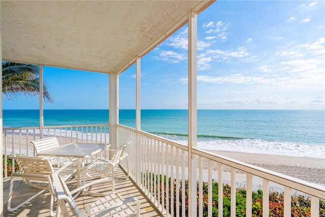 balcony featuring a beach view and a water view