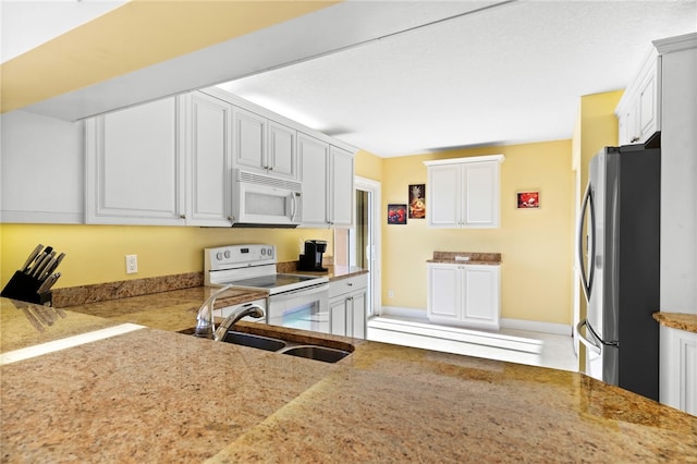 kitchen with white cabinetry, white appliances, and sink