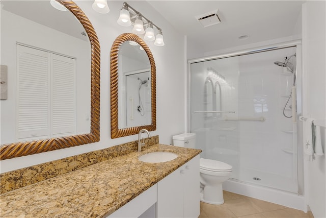 bathroom with toilet, vanity, tile patterned flooring, and walk in shower