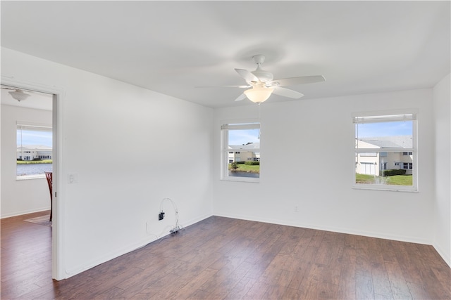 empty room featuring dark wood-type flooring and ceiling fan