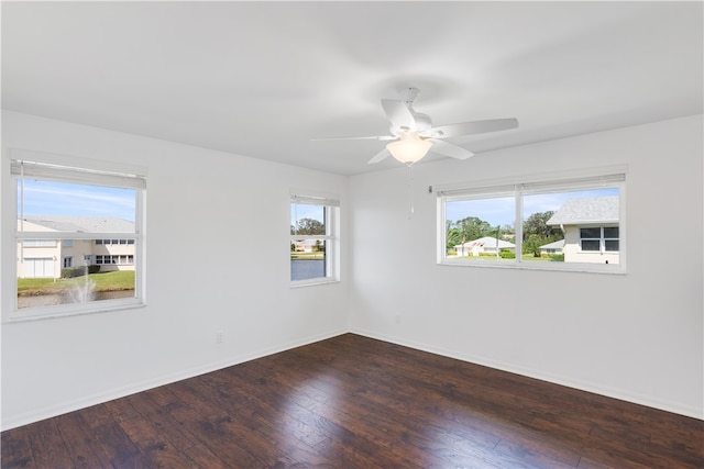 unfurnished room with a wealth of natural light, dark hardwood / wood-style flooring, and ceiling fan