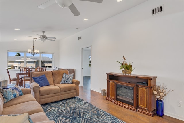 living room with ceiling fan with notable chandelier and hardwood / wood-style flooring