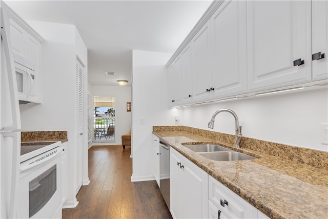 kitchen with white appliances, dark wood-type flooring, white cabinetry, sink, and stone counters