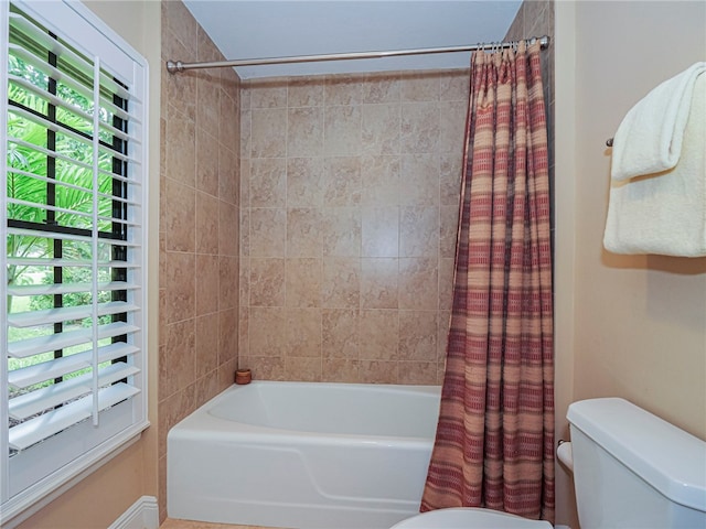 bathroom with toilet and shower / bath combo with shower curtain