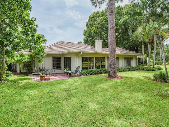 back of house with a patio and a yard