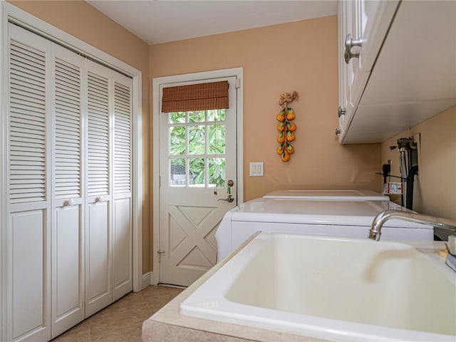 washroom with washer and clothes dryer, cabinets, sink, and light tile patterned floors