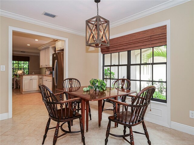 tiled dining room with a chandelier, a healthy amount of sunlight, and crown molding