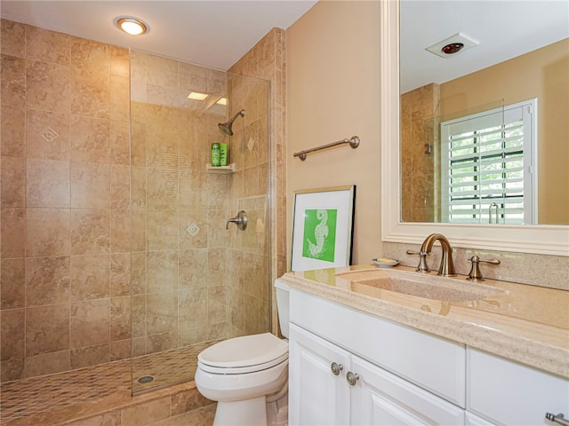 bathroom featuring tiled shower, vanity, and toilet