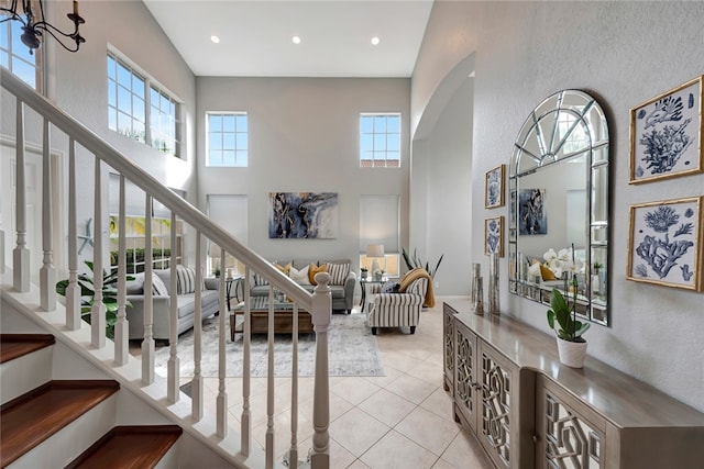 staircase featuring tile patterned flooring and a towering ceiling