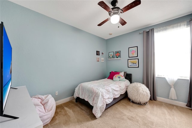 carpeted bedroom featuring multiple windows and ceiling fan