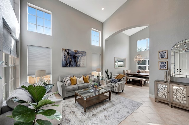 living room featuring high vaulted ceiling, a chandelier, and light tile patterned floors