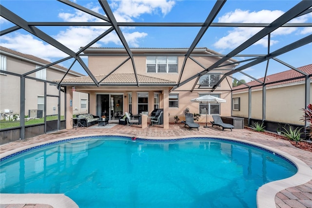 view of pool with glass enclosure, a patio, and an outdoor hangout area