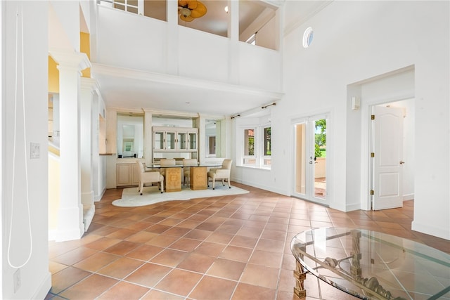 tiled entryway with a high ceiling and ornate columns