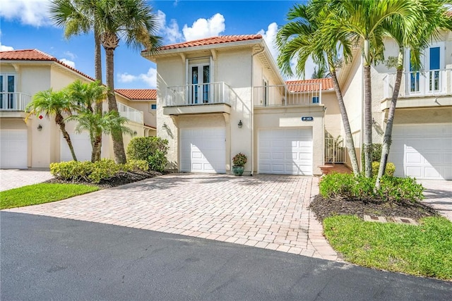 1401 Saint Davids Ln, Vero Beach, FL 32967 - view of front of property featuring a tile roof, a balcony, decorative driveway, stucco siding, and an attached garage