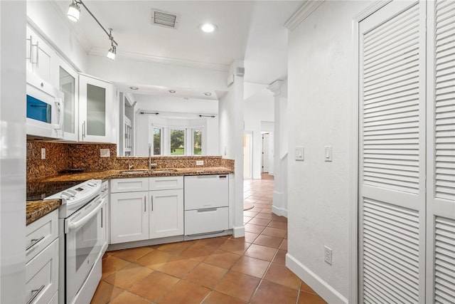 1401 Saint Davids Ln, Vero Beach, FL 32967 - kitchen with white appliances, a sink, light tile patterned floors, glass insert cabinets, and decorative backsplash