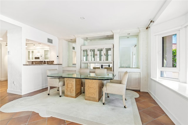 dining space with decorative columns and light tile patterned flooring