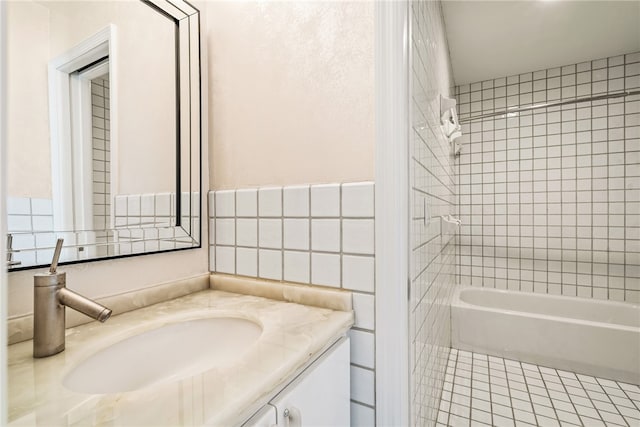 bathroom featuring tile patterned flooring, vanity, and tiled shower / bath combo