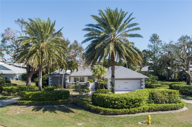 ranch-style house featuring a garage and a front yard