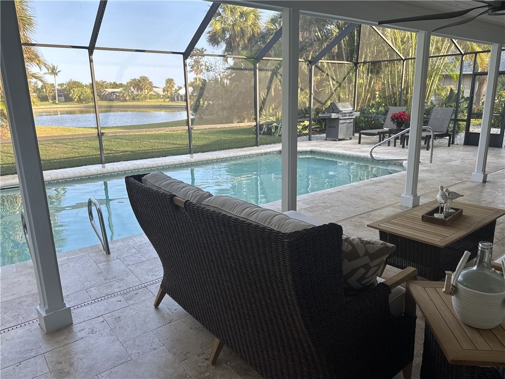 view of swimming pool featuring grilling area and a water view