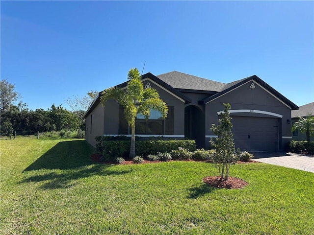 single story home with decorative driveway, a front lawn, an attached garage, and stucco siding