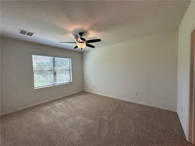 unfurnished room featuring visible vents, carpet floors, a textured ceiling, and a ceiling fan