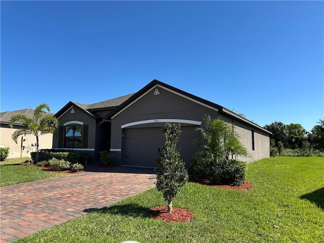 view of front of house with stucco siding, an attached garage, decorative driveway, and a front yard