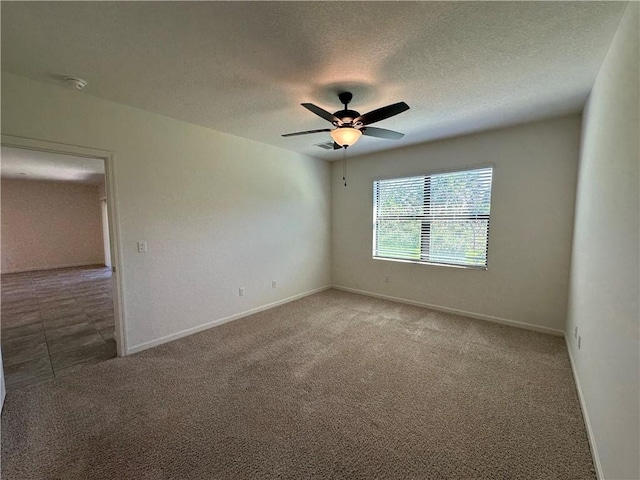 spare room with visible vents, a ceiling fan, a textured ceiling, carpet flooring, and baseboards