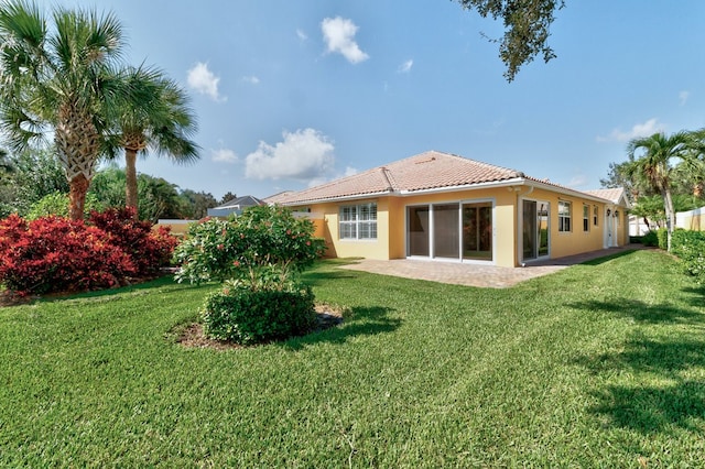 rear view of property featuring a patio and a yard