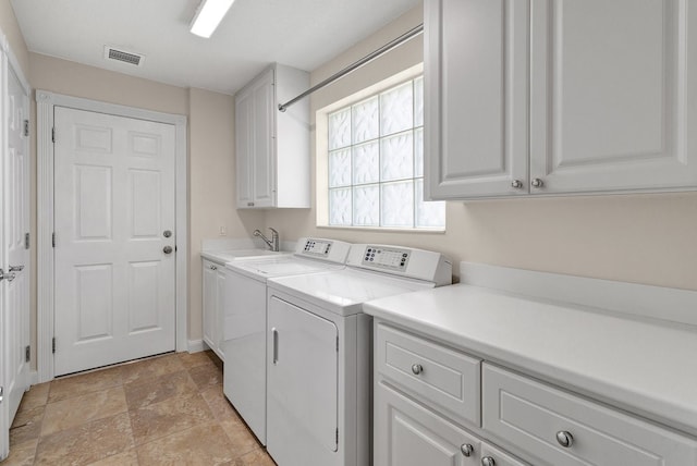 washroom with cabinets, sink, and washer and clothes dryer