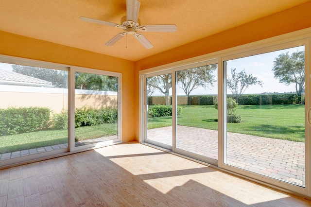 unfurnished sunroom with ceiling fan