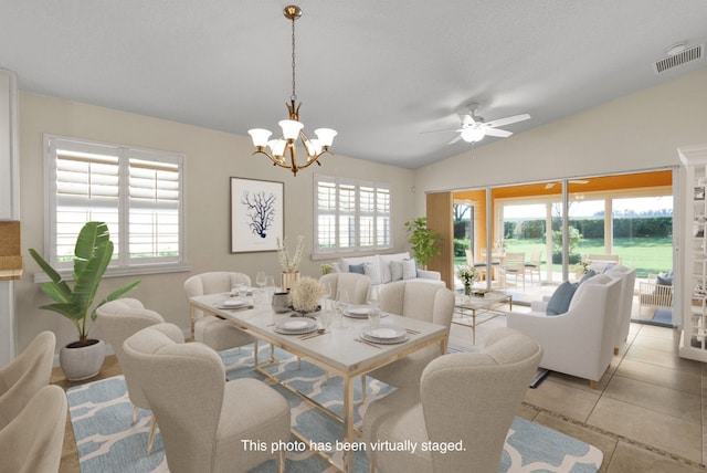 tiled dining area with ceiling fan with notable chandelier and lofted ceiling